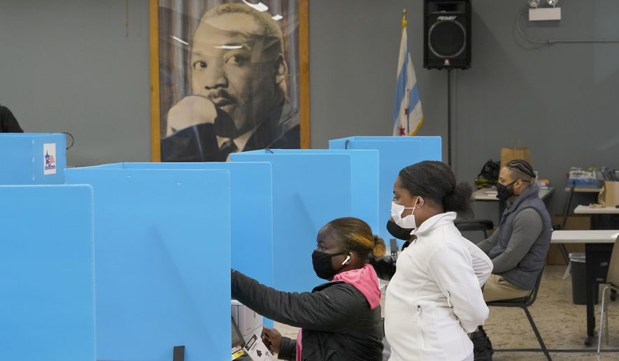 FILE - Jeniya Garrett, right, watches her aunt Catherina Neal vote on Election Day on Nov. 3, 2020, at the Dr. Martin Luther King Community Center in the Bronzeville neighborhood of Chicago. Illinois voters have the chance to sign up to send their ballots for the November 2022 election and spring elections by mail — forever. Elections officials are sending applications for permanent permission to vote by mail to each of the state’s 8 million registered voters. (AP Photo/Charles Rex Arbogast, File)