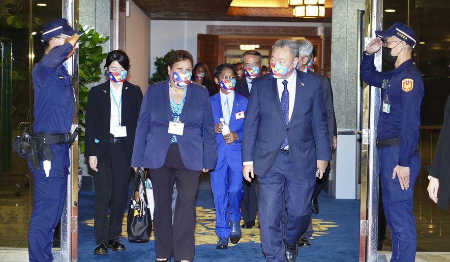 In this photo released by the Taiwan Ministry of Foreign Affairs, Palau&#39;s Vice President J. Uduch Sengebau Senior, third from left walk with her delegation and Taiwan officials after arriving at the Taoyuan airport near Taipei, Taiwan on Saturday, Aug 27, 2022. Palau&#39;s vice president and her eight-member delegation have been quarantined in Taiwan after two of them tested positive for the coronavirus. (Taiwan Ministry of Foreign Affairs via AP)
