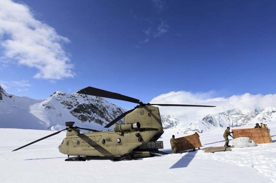 Soldiers and National Park Service personnel offload equipment and supplies from a U.S. Army CH-47 Chinook helicopter on Kahiltna Glacier on April 27, 2022. The Army says it has grounded its fleet of Chinook cargo helicopters after fuel leaks caused a &quot;small number&quot; of engine fires. (John Pennell/U.S. Army via AP, File)