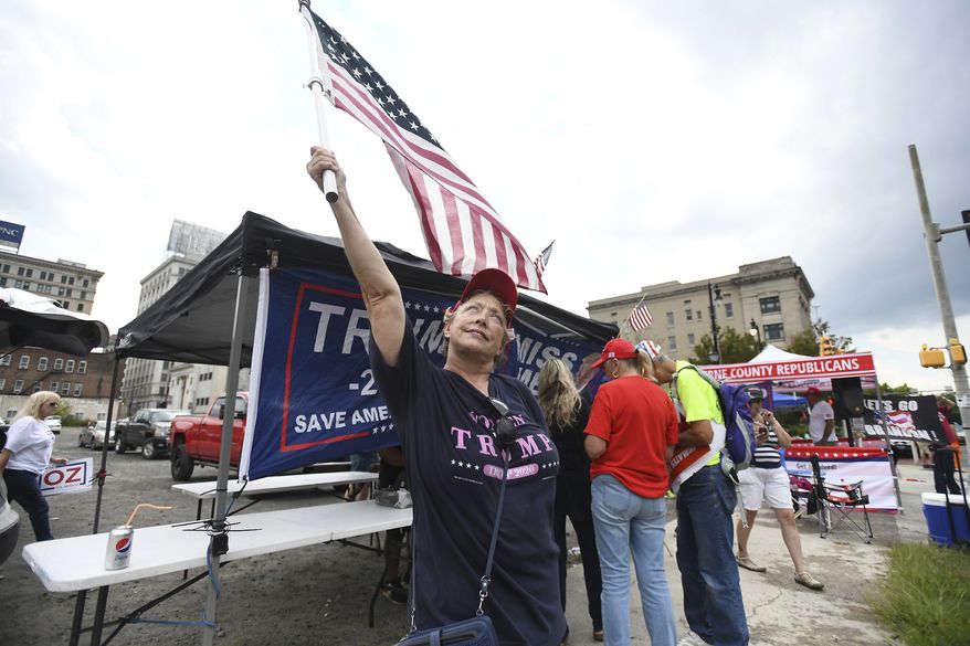 Linda Touhsant attends a rally for former President Donald Trump while waiting for President Joe Biden's Presidential motorcade to pass by in Wilkes-Barre, Pa., Tuesday, Aug. 30, 2022. Biden arrived in Pennsylvania to talk up his administration's plans to prevent crime, an issue that has become potent politically both in this state and nationwide ahead of November's midterm elections. (Mark Moran/The Citizens' Voice via AP)