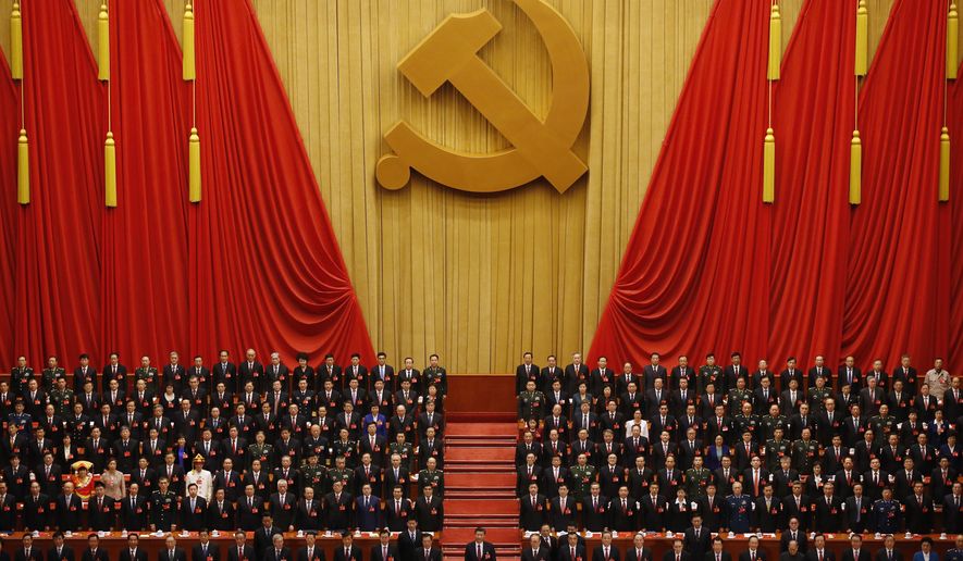FILE - Chinese President Xi Jinping, front row center, stands with his cadres during the Communist song at the closing ceremony for the 19th Party Congress at the Great Hall of the People in Beijing on Oct. 24, 2017. China's long-ruling Communist Party on Tuesday, Aug. 30, 2022, set October 16 for its 20th party congress, at which leader Xi is expected to be given a third five-year term. (AP Photo/Ng Han Guan, File)