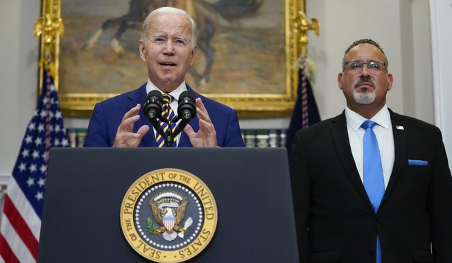 President Joe Biden speaks about student loan debt forgiveness in the Roosevelt Room of the White House, Aug. 24, 2022, in Washington. Education Secretary Miguel Cardona listens at right. (AP Photo/Evan Vucci, File)