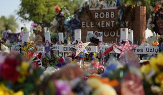 Crosses, flowers and other memorabilia form a make-shift memorial for the victims of the shootings at Robb Elementary School in Uvalde, Texas, July 10, 2022. The Associated Press and other news organizations are suing officials in Uvalde after months of refusal to publicly release records related to the May 2022 shooting at the elementary school. (AP Photo/Eric Gay, File)