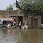 A family salvages belongings from their flood-hit home in Shikarpur district of Sindh province, of Pakistan, Wednesday, Aug. 31, 2022. Officials in Pakistan raised concerns Wednesday over the spread of waterborne diseases among thousands of flood victims as flood waters from powerful monsoon rains began to recede in many parts of the country. (AP Photo/Fareed Khan)