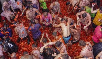 Revellers throw tomatoes at each other during the annual &amp;quot;Tomatina&amp;quot;, tomato fight fiesta in the village of Bunol near Valencia, Spain, Wednesday, Aug. 31, 2022. The tomato fight took place once again following a two-year suspension owing to the coronavirus pandemic. (AP Photo/Alberto Saiz)