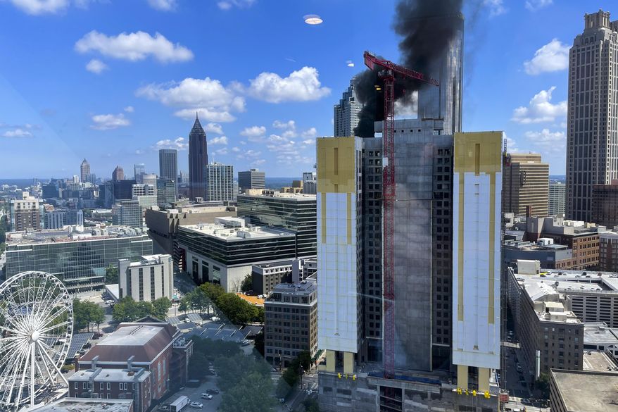 Smoke rises off a building under construction in downtown Atlanta on Wednesday, Aug. 31, 2022. (AP Photo/Mike Warren)