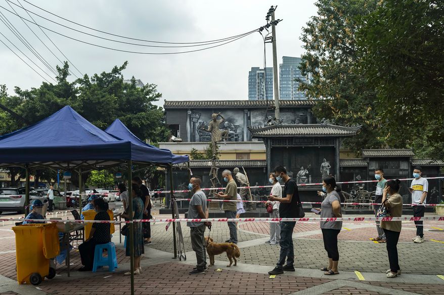 Residents line up for COVID-19 screenings in Chengdu in southwestern China's Sichuan province on Tuesday, Aug. 30, 2022. Chinese authorities have locked down Chengdu, a southwestern city of 21 million people, following a spike in COVID-19 cases. (Chinatopix Via AP)