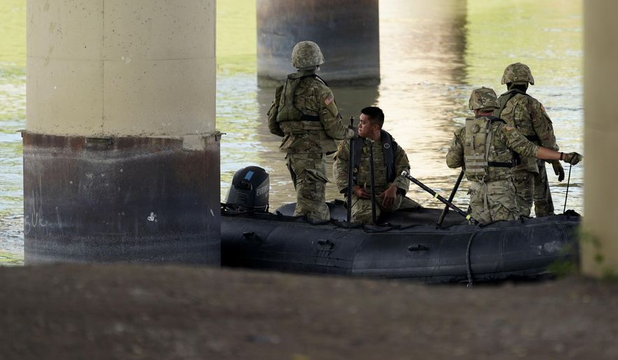 Texas National Guard help patrol looks the Rio Grande near Eagle Pass, Texas, Friday, Aug. 26, 2022. The area has become entangled in a turf war between the Biden administration and Texas Gov. Greg Abbott over how to police the U.S. border with Mexico. (AP Photo/Eric Gay) **FILE**
