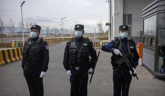 Police officers stand at the outer entrance of the Urumqi No. 3 Detention Center in Dabancheng in western China&#39;s Xinjiang Uyghur Autonomous Region on April 23, 2021. State officials took AP journalists on a tour of a &amp;quot;training center&amp;quot; turned detention site in Dabancheng sprawling over 220 acres and estimated to hold at least 10,000 prisoners - making it by far the largest detention center in China and among the largest on the planet. (AP Photo/Mark Schiefelbein, File)