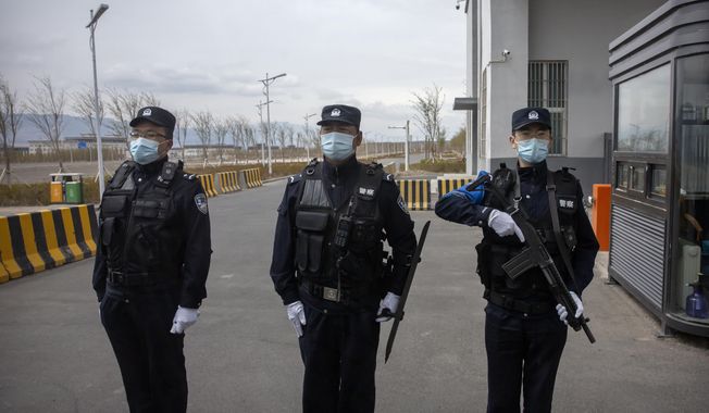 Police officers stand at the outer entrance of the Urumqi No. 3 Detention Center in Dabancheng in western China&#x27;s Xinjiang Uyghur Autonomous Region on April 23, 2021. State officials took AP journalists on a tour of a &amp;quot;training center&amp;quot; turned detention site in Dabancheng sprawling over 220 acres and estimated to hold at least 10,000 prisoners - making it by far the largest detention center in China and among the largest on the planet. (AP Photo/Mark Schiefelbein, File)