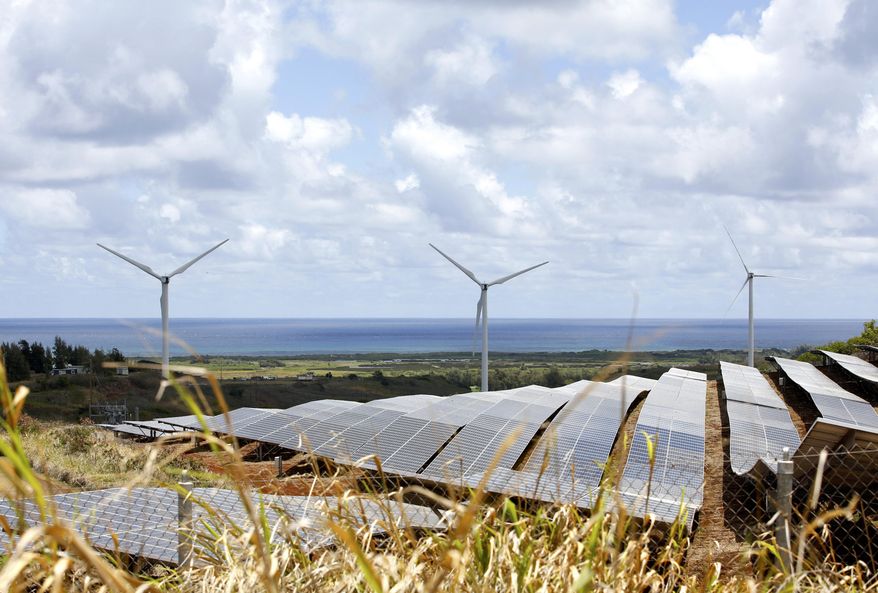 Windmills and solar panels are shown in Kahuku, Hawaii on Monday, Aug. 22, 2022. As Hawaii transitions toward its goal of achieving 100% renewable energy by 2045, the state&#39;s last coal-fired power plant closed this week ahead of a state law that bans the use of coal as a source of electricity beginning in 2023. (AP Photo/Caleb Jones)