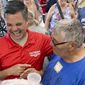 Iowa Republican candidate for Congress Zach Nunn, left, laughs while talking with Arvin Foell of Kelley, Iowa, during an appearance at the Iowa State Fair, in Des Moines, Iowa, August 12, 2022. Nunn is among more than a dozen strict abortion opponents running in competitive House, Senate and governor races working to soften his profile in light of increased enthusiasm among Democratic voters since the June U.S. Supreme Court decision reversing a federal right to abortion. (AP Photo/Thomas Beaumont)