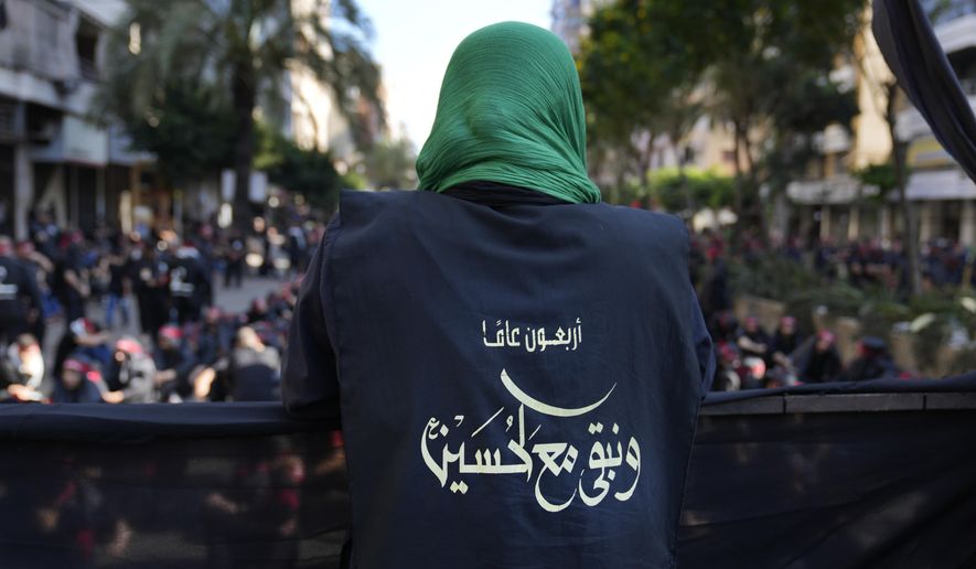 A Hezbollah member wears a vest with Arabic that reads: &amp;quot;40 years and we stay with Hussein (the Prophet Muhammad&#x27;s grand son),&amp;quot; during the holy day of Ashoura that commemorates the 7th century martyrdom of the Prophet Muhammad&#x27;s grandson Hussein, in the southern suburb of Beirut, Lebanon, Aug. 9, 2022. Forty years since it was founded, Lebanon&#x27;s Hezbollah has transformed from a ragtag organization to the largest and most heavily armed militant group in the Middle East. (AP Photo/Hussein Malla)