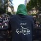 A Hezbollah member wears a vest with Arabic that reads: &amp;quot;40 years and we stay with Hussein (the Prophet Muhammad&#x27;s grand son),&amp;quot; during the holy day of Ashoura that commemorates the 7th century martyrdom of the Prophet Muhammad&#x27;s grandson Hussein, in the southern suburb of Beirut, Lebanon, Aug. 9, 2022. Forty years since it was founded, Lebanon&#x27;s Hezbollah has transformed from a ragtag organization to the largest and most heavily armed militant group in the Middle East. (AP Photo/Hussein Malla)