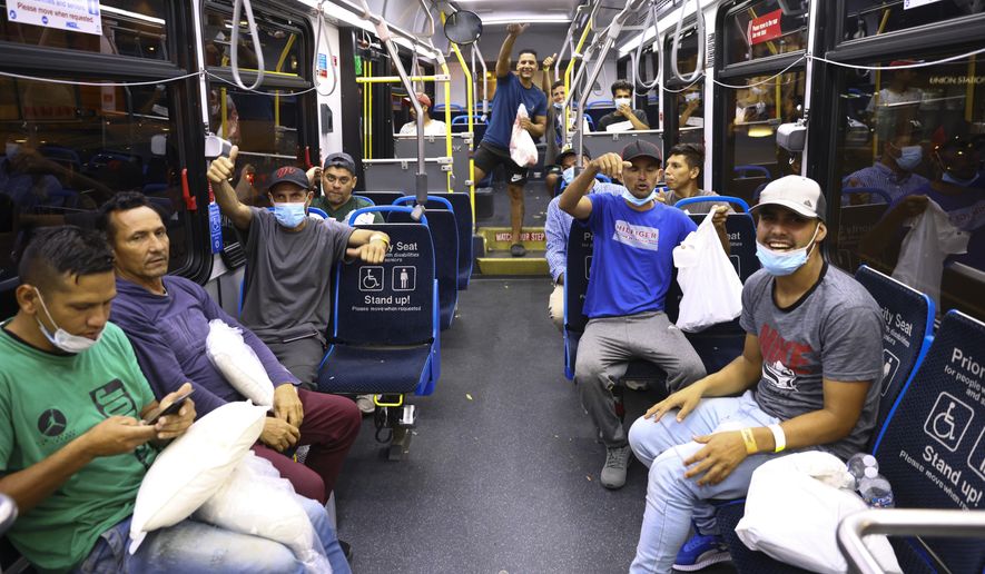 Migrants give a thumbs up and cheer as they load a bus to take them to a refugee center outside Union Station in Chicago, Wednesday, Aug. 31, 2022. Chicago officials say 75 immigrants have arrived in the city on buses from Texas, as part of an aggressive border policy by Texas Gov. Greg Abbott. Mayor Lori Lightfoot&#x27;s office confirmed that the migrants arrived Wednesday night and that the city has welcomed them and will make sure they receive shelter and food. (Anthony Vazquez /Chicago Sun-Times via AP)