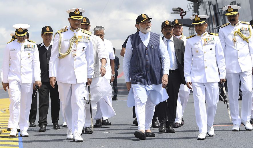 In this handout picture provided by the Press Information Bureau, Indian Prime Minister Narendra Modi inspects the INS Vikrant, India&#39;s first indigenously-built aircraft carrier, during its commissioning in Kochi, India, Friday, Sept. 2, 2022. India on Friday commissioned its first home-built aircraft carrier in its quest to match an aggressive China with a much larger naval fleet. (Press Information Bureau via AP)
