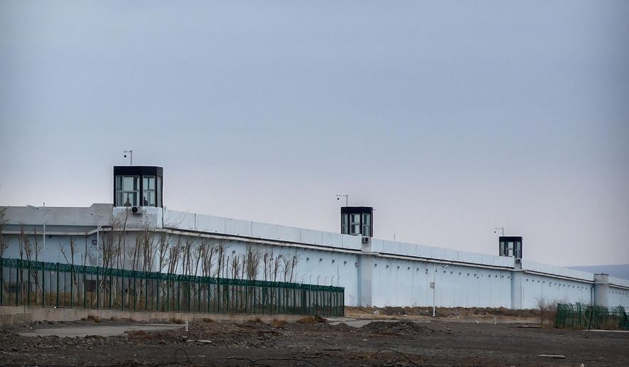 People stand in a guard tower on the perimeter wall of the Urumqi No. 3 Detention Center in Dabancheng in western China's Xinjiang Uyghur Autonomous Region on April 23, 2021. After a U.N. report concluding that China's crackdown in the far west Xinjiang region may constitute crimes against humanity, China used a well-worn tactic to deflect criticism: blame a Western conspiracy. (AP Photo/Mark Schiefelbein, File)