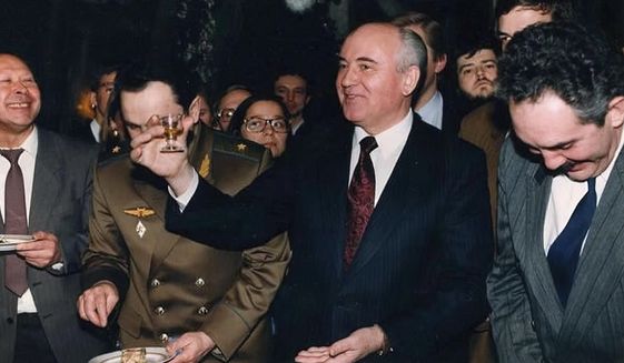 Soviet Union President Mikhail Gorbachev toasts with a small glass of lemon-flavored vodka at a going-away party for his staff on Dec. 26, 1991, the day after his nationally televised address in which he announced his resignation as president, in Moscow. Associated Press correspondent Brian Friedman is back right of Gorbachev. (AP Photo/Alexander Zemlianichenko)