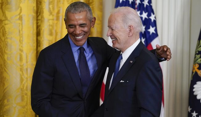 President Joe Biden and former President Barack Obama shake stand together on stage during an event about the Affordable Care Act, in the East Room of the White House in Washington, April 5, 2022. (AP Photo/Carolyn Kaster, File)