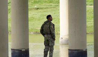 A member of the Texas National Guard looks across the Rio Grande to Mexico from the U.S. at Eagle Pass, Texas, on Aug. 26, 2022. (AP Photo/Eric Gay, File)