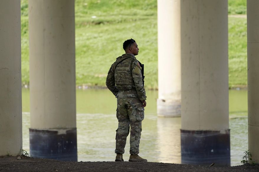 A member of the Texas National Guard looks across the Rio Grande to Mexico from the U.S. at Eagle Pass, Texas, on Aug. 26, 2022. (AP Photo/Eric Gay, File)