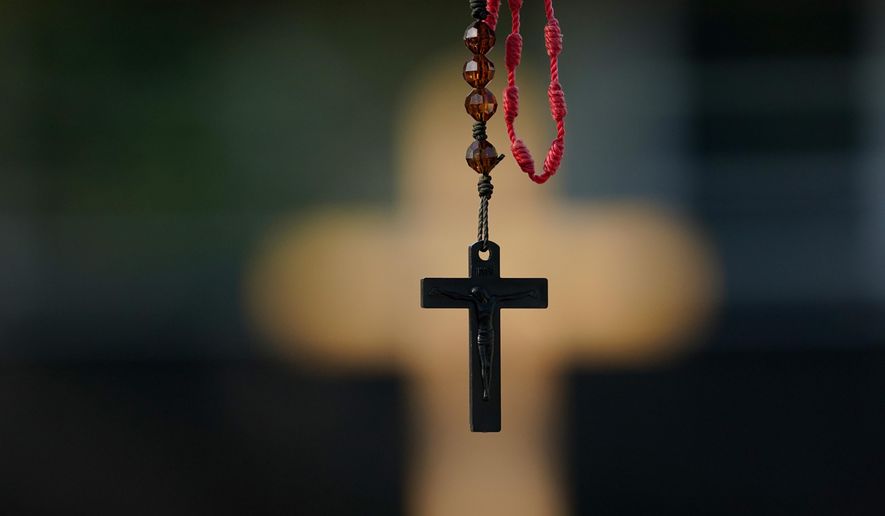 A rosary hangs at a make-shift memorial on Monday, July 11, 2022, in Uvalde, Texas. (AP Photo/Eric Gay)