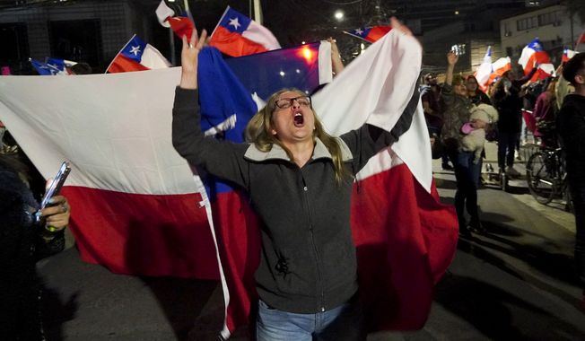 An opponent of the new Constitution celebrates in the streets the results of a plebiscite on whether the new Constitution will replace the current Magna Carta imposed by a military dictatorship 41 years ago, in Santiago, Chile, Sunday, Sept. 4, 2022. (AP Photo/Matias Basualdo)