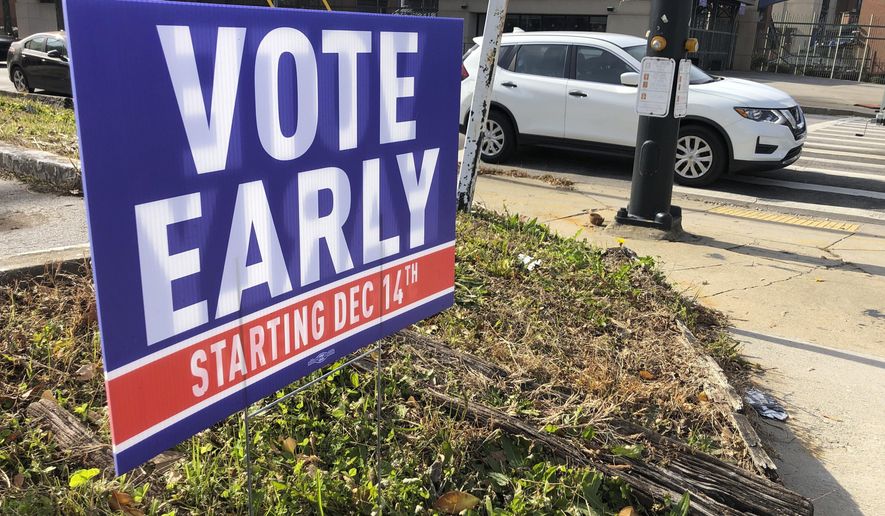 In this Dec. 11, 2020 file photo, a sign in an Atlanta neighborhood urges people to vote early in Georgia&#39;s two U.S. Senate races. (AP Photo/Jeff Amy, File)