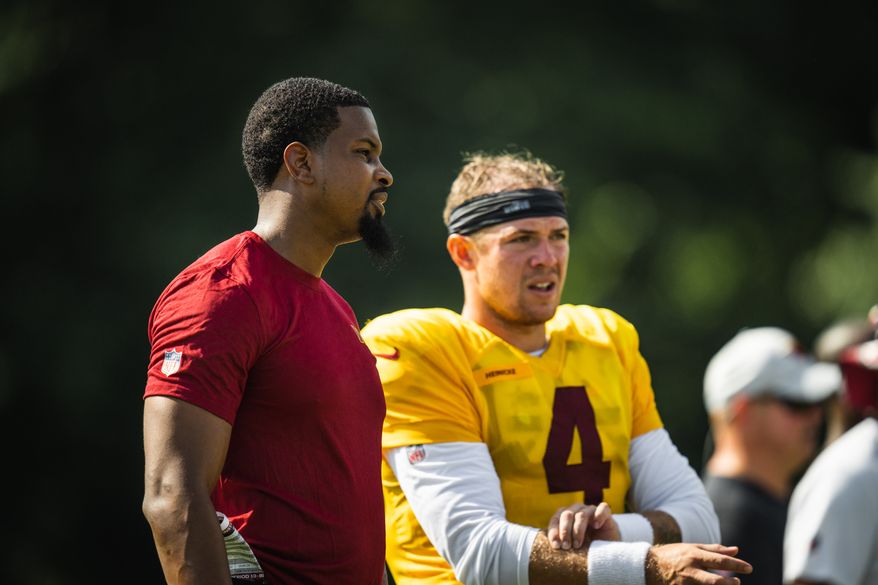 Washington Commanders offensive assistant Tyrae Reid Jr. (left) works with quarterback Taylor Heinicke. (Photo courtesy of the Washington Commanders)