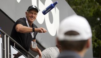 LIV Golf CEO Greg Norman tosses beer to fans on the 18th green during the final round of the LIV Golf Invitational-Boston tournament, Sunday, Sept. 4, 2022, in Bolton, Mass. (AP Photo/Mary Schwalm)