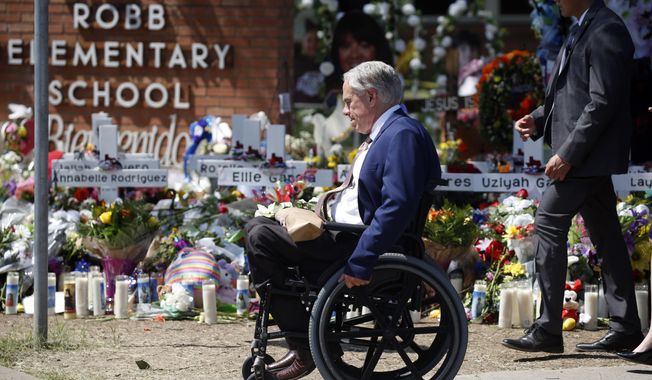 Texas Gov. Greg Abbott passes in front of a memorial outside Robb Elementary School to honor the victims killed in a school shooting in Uvalde, Texas, May 29, 2022.  In the aftermath of the school shooting in Uvalde, Texas, governors around the country vowed to take steps to ensure their students would be kept safe. Months later, as students return to classrooms, money has begun to flow for school security upgrades, training and other new efforts to make classrooms safer.  (AP Photo/Dario Lopez-Mills, File)