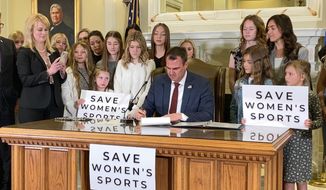 In this March 30, 2022 file photo Oklahoma Gov. Kevin Stitt signs a bill in Oklahoma City that prevents transgender girls and women from competing on female sports teams.  
Attorneys for three Oklahoma students filed a federal lawsuit on Sept. 7, 2022, against the state’s newly enacted single-sex school restroom law, arguing that it discriminates against transgender pupils.(AP Photo/Sean Murphy, File)  **FILE*