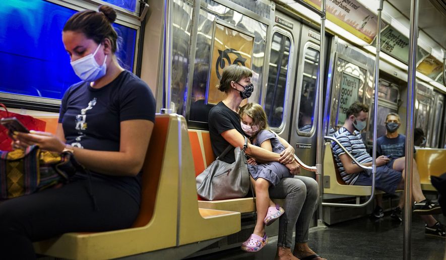 New York City subway passengers wear protective masks due to COVID-19 concerns, Aug. 17, 2020. New York state is dropping its mask requirement on public transportation thanks in part to the availability of new booster shots targeting the most common strain of COVID-19, Gov. Kathy Hochul announced Wednesday, Sept. 7, 2022. (AP Photo/John Minchillo) **FILE**
