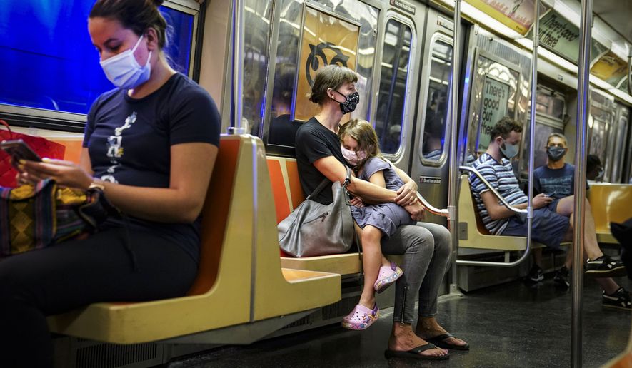 New York City subway passengers wear protective masks due to COVID-19 concerns, Aug. 17, 2020. New York state is dropping its mask requirement on public transportation thanks in part to the availability of new booster shots targeting the most common strain of COVID-19, Gov. Kathy Hochul announced Wednesday, Sept. 7, 2022. (AP Photo/John Minchillo, File)