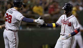 Atlanta Braves&#39; Ronald Acuna Jr., right, is congratulated by Matt Olson (28) after scoring on a sacrifice fly by Austin Riley against the Oakland Athletics during the sixth inning of a baseball game in Oakland, Calif., Tuesday, Sept. 6, 2022. (AP Photo/Jed Jacobsohn)