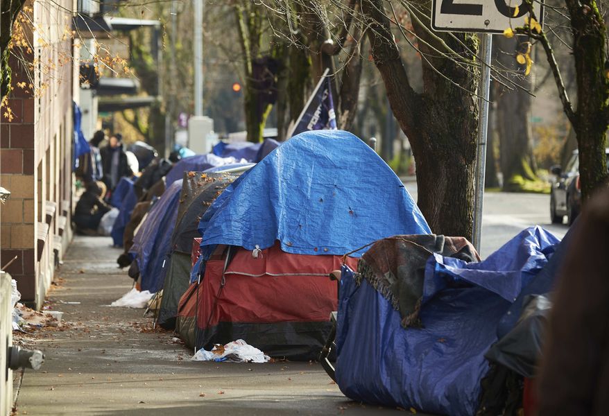 In this file photo, tets line the sidewalk on SW Clay St in Portland, Ore., on Dec. 9, 2020. People with disabilities in Portland have filed a class action lawsuit in federal court, Thursday, Sept. 8, 2022, claiming the city has failed to keep sidewalks accessible by allowing homeless tents and encampments to block sidewalks.  (AP Photo/Craig Mitchelldyer, File)  **FILE**