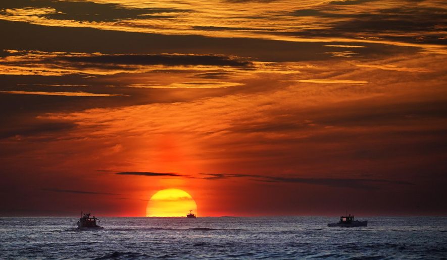 Lobster fishermen are already at work as the sun rises over the Atlantic Ocean, Thursday, Sept. 9, 2022, off of Kennebunkport, Maine. (AP Phot6o/Robert F. Bukaty)