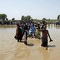 Victims of unprecedented flooding from monsoon rains line up to receive relief aid organized by the Edhi Foundation, in the Ghotki District of Sindh Pakistan, Wednesday, Sept. 7, 2022. (AP Photo/Fareed Khan)