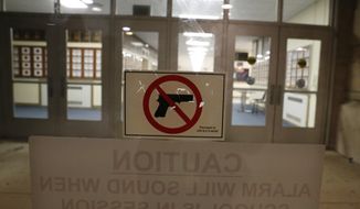 A no-gun sticker is displayed a doorway at Oak Park and River Forest High School on Thursday, Aug. 25, 2022, in Oak Park, Ill. Despite laws banning guns from schools, educators in cities, suburbs and rural areas say keeping guns out of schools is difficult. (AP Photo/Martha Irvine)