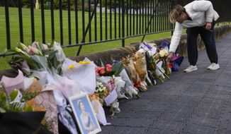A man lays flowers at a floral tribute outside Government House following the passing of Queen Elizabeth II in Sydney, Australia, Friday, Sept. 9, 2022. Queen Elizabeth II, Britain&#39;s longest-reigning monarch and a rock of stability in a turbulent era for her country and the world, died Thursday, Sept. 8 after 70 years on the throne. She was 96. (AP Photo/Mark Baker)
