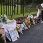 A man lays flowers at a floral tribute outside Government House following the passing of Queen Elizabeth II in Sydney, Australia, Friday, Sept. 9, 2022. Queen Elizabeth II, Britain&#39;s longest-reigning monarch and a rock of stability in a turbulent era for her country and the world, died Thursday, Sept. 8 after 70 years on the throne. She was 96. (AP Photo/Mark Baker)