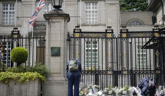 A man bows as another leave flowers outside the British Embassy following the death of Queen Elizabeth II, Friday, Sept. 9, 2022, in Tokyo. Queen Elizabeth II, Britain&#39;s longest-reigning monarch and a rock of stability across much of a turbulent century, died Thursday after 70 years on the throne. She was 96. (AP Photo/Eugene Hoshiko)