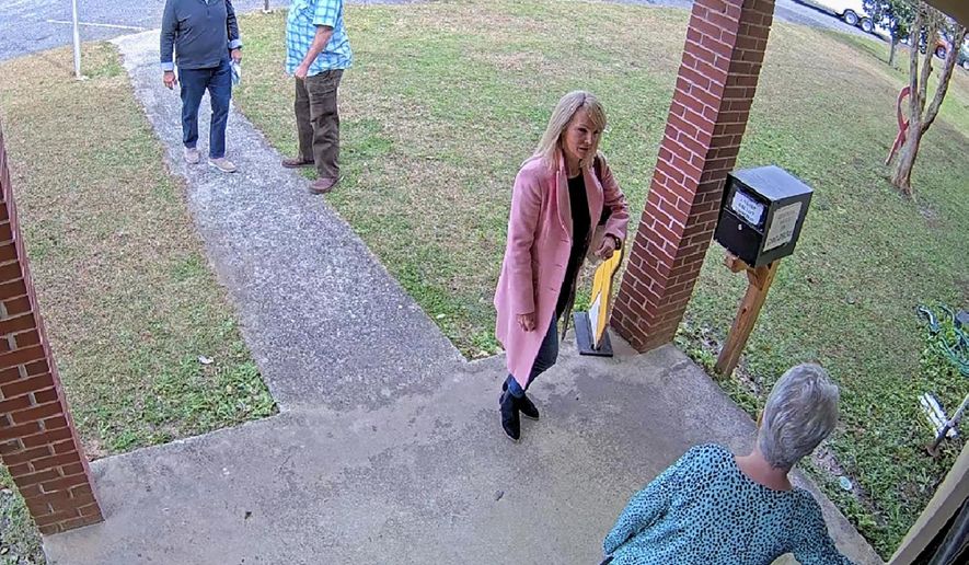 In this Jan. 7, 2021 image taken from Coffee County, Ga., security video, Cathy Latham, bottom, who was the chair of the Coffee County Republican Party at the time, greets a team of computer experts from data solutions company SullivanStrickler at the county elections office in Douglas, Ga. Records show that the team traveled to the rural south Georgia county to copy software and data from elections equipment. The Georgia secretary of state&#39;s office has said the visit was an &amp;quot;alleged unauthorized access&amp;quot; of election equipment. (Coffee County via AP)