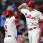 Philadelphia Phillies&#39; J.T. Realmuto, right, and Jean Segura celebrate after Realmuto&#39;s home run against Washington Nationals pitcher Patrick Corbin during the sixth inning of a baseball game, Friday, Sept. 9, 2022, in Philadelphia. (AP Photo/Matt Slocum)