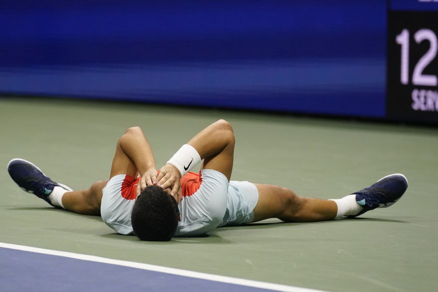 Carlos Alcaraz, of Spain, lays on the court after defeating Frances Tiafoe, of the United States, during the semifinals of the U.S. Open tennis championships, Friday, Sept. 9, 2022, in New York. (AP Photo/Charles Krupa)