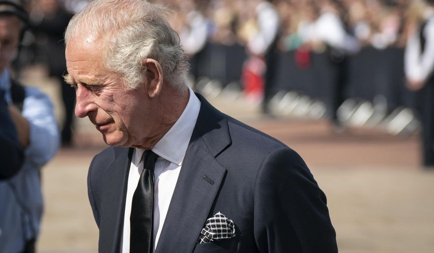 Britain&#39;s King Charles III, looks at flowers outside Buckingham Palace following Thursday&#39;s death of Queen Elizabeth II, in London, Friday Sept. 9, 2022. King Charles III, who spent much of his 73 years preparing for the role, planned to meet with the prime minister and address a nation grieving the only British monarch most of the world had known. He takes the throne in an era of uncertainty for both his country and the monarchy itself. (Dominic Lipinski/PA via AP)