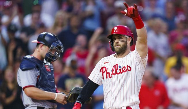 Philadelphia Phillies&#x27; Bryce Harper, right, reacts to his two-run home run, next to Washington Nationals catcher Riley Adams during the third inning of a baseball game Saturday, Sept. 10, 2022, in Philadelphia. (AP Photo/Chris Szagola)