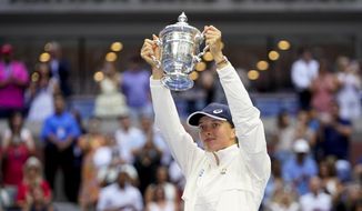 Iga Swiatek, of Poland, holds up the championship trophy after defeating Ons Jabeur, of Tunisia, to win the women&#39;s singles final of the U.S. Open tennis championships, Saturday, Sept. 10, 2022, in New York. (AP Photo/Frank Franklin II)