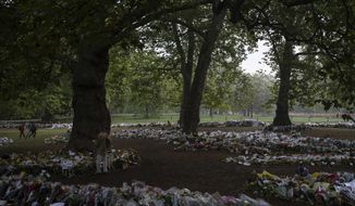 Mourners lay flowers for Queen Elizabeth II at Green Park, near Buckingham Palace in London, Sunday, Sept. 11, 2022. (AP Photo/Felipe Dana)