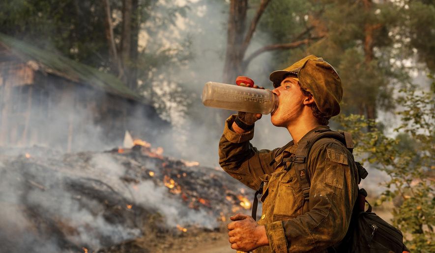Firefighter Trapper Gephart of Alaska&#39;s Pioneer Peak Interagency Hotshot crew takes a drink while battling the Mosquito Fire in the Volcanoville community of El Dorado County, Calif., on Friday, Sept. 9, 2022. (AP Photo/Noah Berger)